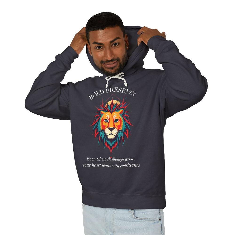 Young man with short hair pulling up the hood of a dark gray hoodie featuring vibrant multicolored lion head graphic, mane in orange teal blue splashes, "BOLD PRESENCE" arched text, motivational quote about heart-led confidence below