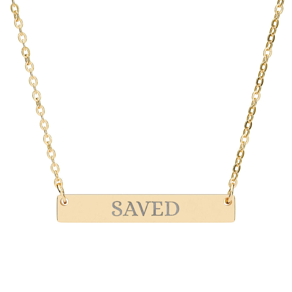 Gold bar necklace with engraved uppercase text "SAVED" on a sleek matte pendant, suspended on a delicate matching gold chain. Minimalist motivational affirmation jewelry for grace, redemption, and spiritual protection.