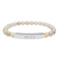 Bracelet with polished pastel beads in soft peach, cream, gray, and light blue tones with natural marbling, featuring a silver curved bar engraved "ARIES" in uppercase letters. Stretch-fit zodiac-inspired crystal jewelry.