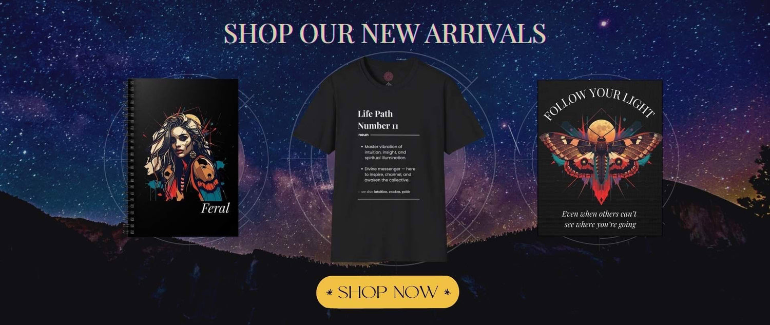 New Arrivals banner for Mystodiac spiritual shop featuring cosmic starry background with Life Path Number black t-shirt, Feral Divine Feminine notebook, and Follow Your Light Moth spirit animal notebook, including SHOP NOW button